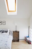 Attic bedroom with upturned fruit crate as bedside table and pillow with Moomins print