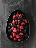 Fresh blackberries and raspberries in a dish (view from above)