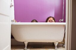 Mixed race girls playing in bathtub