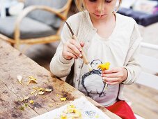 A girl cleaning chanterelle mushrooms with a brush