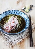 Cha Soba (buckwheat noodles with green tea) in broth, garnished with surimi strips