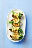 Grilled, rolled strips of courgette stuffed with sundried tomatoes, feta and rocket