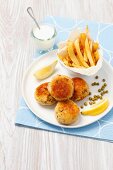 Fishcakes with peas, chips and a cream dip