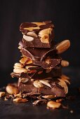 Mehrere Schokoladenstücke mit Nüssen und Mandeln, gestapelt