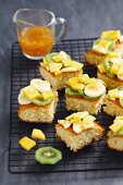 Coconut sponge cake with tropical fruits, cut into pieces