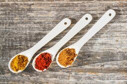 Three spoons of different spices from above