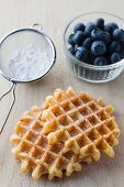 Waffles with icing sugar and fresh blueberries