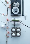 Abstrakte Deko mit Kabelbindern, Eiern und einen Blütenzweig