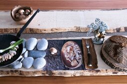 Stylised meal of mushrooms and bread with rustic ornaments of wood and stone