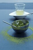 Grünes Teepulver in Schale und Abdruck