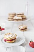 Jam biscuit on a plate with icing sugar.