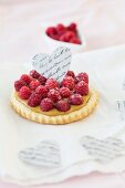 A raspberry tartlet decorated with a paper heart