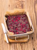 Chocolate cake with cranberries in a baking tin