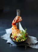 Prawns with vegetables and chives on a spoon
