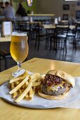 A cheeseburger with chips and beer