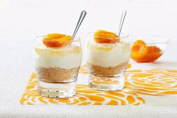 Mini cheesecakes in glasses garnished with apricots