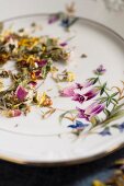 A mixture of herbs with various flowers on an old-fashioned plate