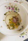 Herbal tea mixture with various flowers in an old-fashioned cup (close-up)