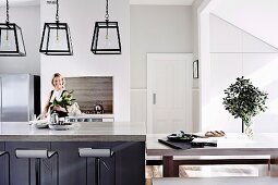 Küche in schlichtem modernem Design mit Kücheninsel & Barhockern