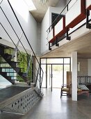 Purist steel staircase and glazed door element in foyer of contemporary house with gallery