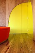 Moderne gebogene, gelbgrüne Zimmertür in Holzwand eines Vorraumes