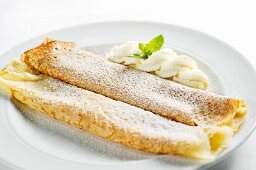 Pancakes filled with apricot jam, whipped cream and icing sugar