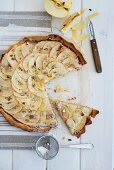 An apple tart with dulce de leche and pecan nuts, sliced