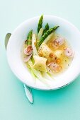 Asparagus broth with dumplings and onion rings