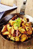 Fried potatoes with bacon in a pan