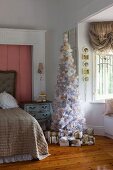 White and gold romantic Christmas tree and wrapped presents in faux-antique girl's bedroom
