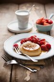 Creme caramel with coconut, strawberries and raspberries