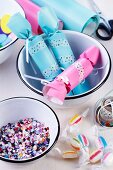 Pastel crackers decorated with washi tape and confetti in enamel bowls