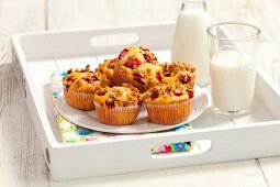 Erdbeer-Müsli-Muffins und Milch auf Tablett