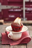 A chocolate muffin decorated with a pear