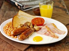 Englisches Frühstück mit Würstchen, Bacon, Spiegelei, Baked Beans und Toast