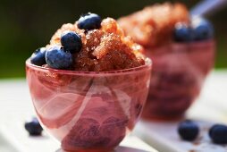 Blueberry granita with fresh blueberries in pink glass bowls