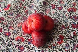 Freshly washed organic plums on a floral cloth