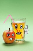 Apfelgesicht und ein Glas Apfelsaft mit Gesicht