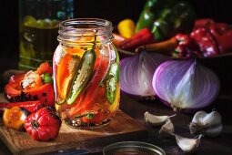 Various preserved peppers and chillis with garlic, onions and olive oil