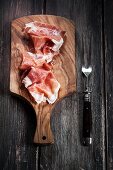 Sliced Parma ham on a wooden board