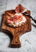 Crisp bread with Parma ham on a wooden board