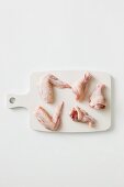 Chicken wings and legs on a chopping board