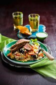 Grilled lamb on a bed of couscous with fried vegetables