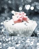 A festive cupcake decorated with silver pearls and sugar flowers