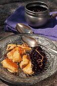 Glazed shredded pancake with an orange and blueberry sauce