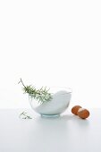 An arrangement of ingredients with salt, rosemary and eggs