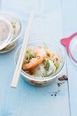 Oriental noodle soup with prawns and chicken cooked in a jar