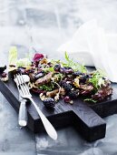 A mixed leaf salad with chicken and blackberries