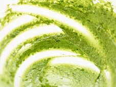 Remains of herb butter in a glass bowl (close-up)