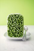 A block of frozen peas with a spoon